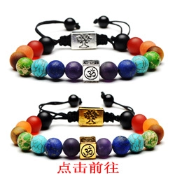 Macro detail of chakra beaded bracelets featuring Om and Tree of Life charms on woven cord