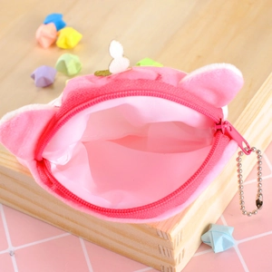 Pink plush unicorn coin purse with zipper and metal chain on a decorative background
