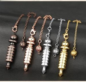 Macro detail of spiral metal dowsing pendulums in gold, silver, bronze and rose gold