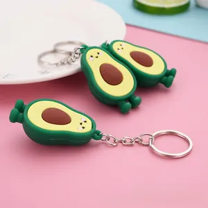 Macro shot of 3D avocado keychains on a pink surface with creative props