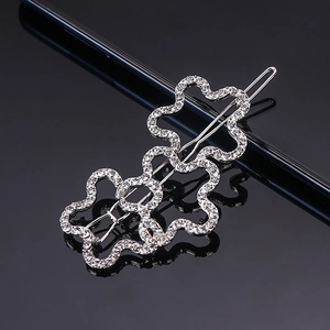 Elegant wavy silver hair clip with sparkling white rhinestones on black background