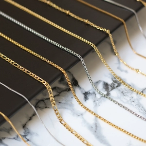 Detail shot of gold and silver titanium steel necklaces in various chain link styles