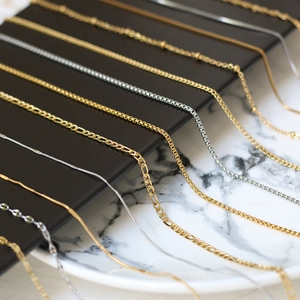 Collection of gold and silver stainless steel bead and lip link chains on a display