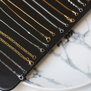 Macro shot of assorted gold and silver stainless steel chain link styles on black display