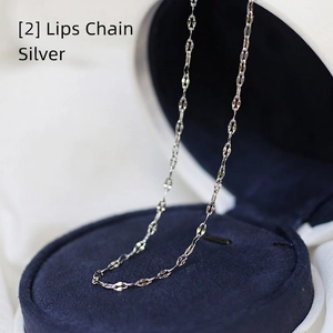 Macro shot of silver lip chain link necklace on dark blue velvet jewelry box display