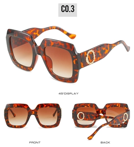 Détail de lunettes de soleil oversize écaille avec accents dorés et verres dégradés