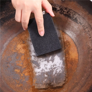 High-density carborundum sponge cleaning a rusty iron pot to remove stains and lime