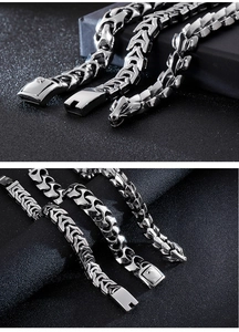 Detail view of silver dragon scale bracelets with ornate clasp on dark background