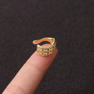Close-up of a gold-toned micro-paved ear cuff with rhinestones on a finger
