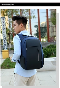 Zaino porta PC aziendale in blu navy e nero indossato da un modello in un contesto urbano