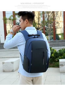 Vista laterale dello zaino porta PC blu e nero indossato da un modello in città
