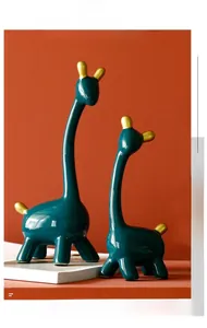 Nahaufnahme der Morandi-Giraffenfiguren aus Keramik mit Goldakzenten auf orangefarbenem Grund