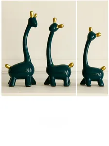 Detail von modernen dunkelgrünen Keramik-Giraffenfiguren mit eleganten Goldakzenten