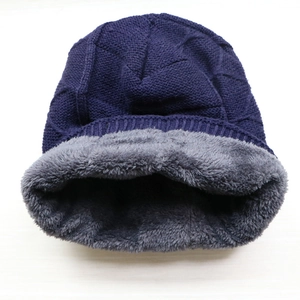 Detailed view of the warm fleece lining and navy blue knit texture of this winter beanie