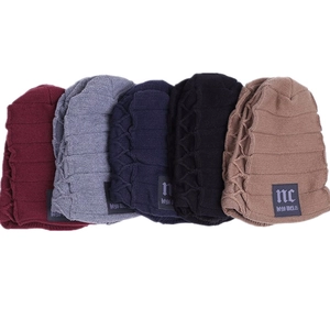 Detail showing five colors of winter knit beanies with fleece lining and NC label