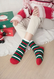 Detailed close-up of thick striped coral fleece Christmas socks with festive decorations