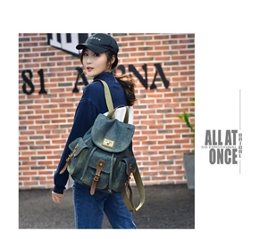 Dettaglio dello zaino vintage in denim con fibbie in pelle marrone e tasche cargo
