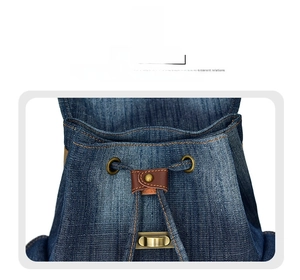 Dettaglio dello zaino in denim blu con coulisse in pelle marrone e fibbia dorata