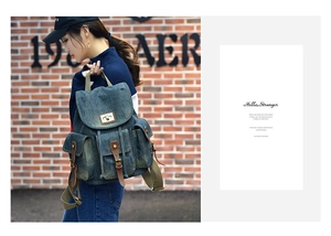 Dettaglio dello zaino vintage in denim blu con cinturini in pelle marrone e tasche ampie