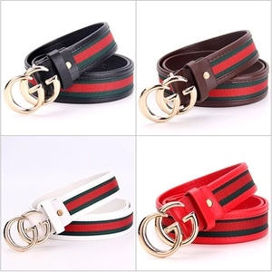 Close-up of fashion waist belts with striped webbing and gold buckles in four colors