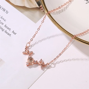 Close-up of rose gold antler pendant with sparkling stones and projection stone center