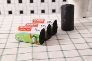 Close-up of thickened black roll-on garbage bags on a checkered cloth for home kitchen use