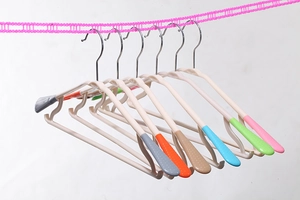 Detail of colorful non-slip clothes hangers with metal hooks and wide plastic shoulders