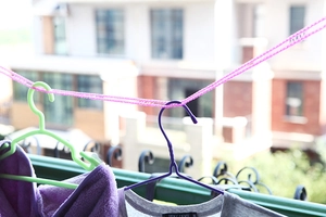 Windproof non-slip pink laundry rope with hangers on a balcony outdoor setting