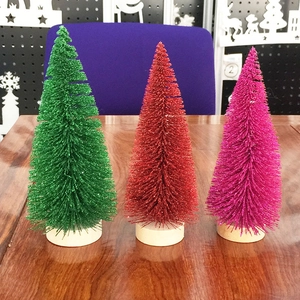 Glittering green, red and pink mini cedar Christmas trees with natural wood bases