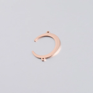 Macro detail of rose gold crescent moon connector with double holes for jewelry making