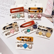 Close-up of floral bow hair clip set with tortoise shell and faux pearls on magazine background