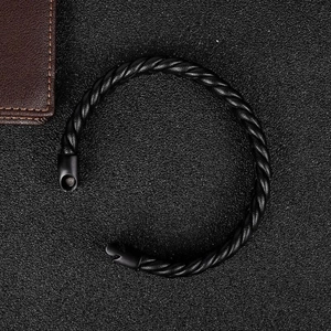 Vista dettagliata del bracciale in pelle nera intrecciata con chiusura in metallo nero