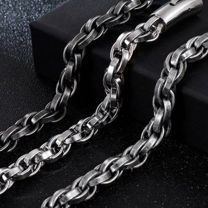 Vintage stainless steel chain bracelet with lobster clasp on a textured black surface
