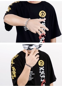 Detail of silver and gunmetal double weave chain bracelets worn by a male model