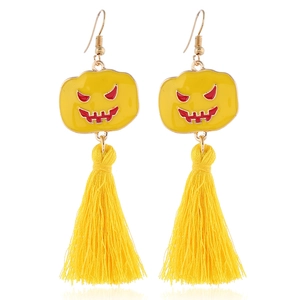 Detail of Halloween earrings featuring yellow pumpkin charms and soft silk tassels