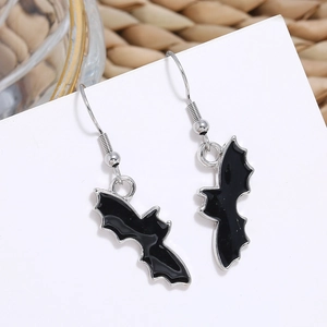 Close-up of black bat earrings with silver trim hanging on white display card