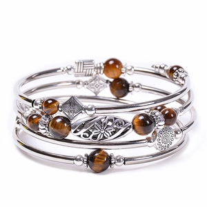 Detailed macro of vintage bohemian multi-layer silver bracelet with brown tiger eye beads