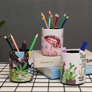Detailed view of ceramic pencil holders featuring botanical leaves and cactus patterns