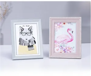 Close-up of Nordic style photo frames in light blue and pink with wood grain texture