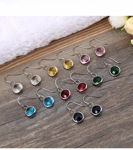 Detail of round faceted crystal hook earrings in seven vibrant colors on wood and fur