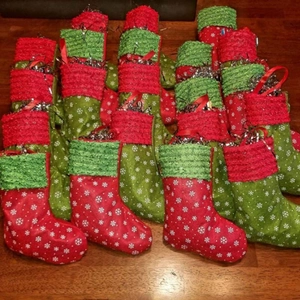 Red and green Christmas stockings with snowflake patterns on a rustic wooden floor