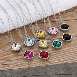 Detail view of 15mm glass pendant necklaces in multiple colors on a wooden display