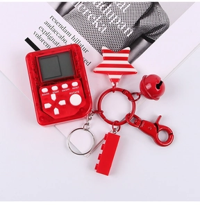 Dettaglio portachiavi mini console Tetris rossa con ciondoli a stella e campanellino.
