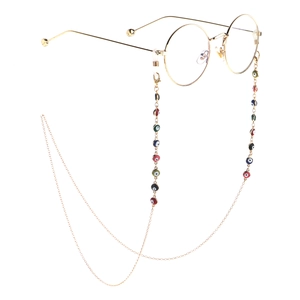 Golden round glasses with colorful evil eye charm chain on a white background