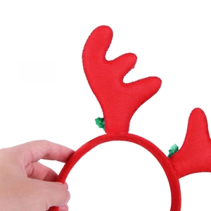 Detail view of the back side of red Christmas reindeer antlers headband with green leaves