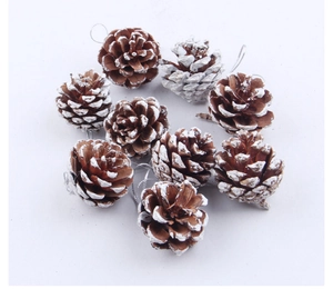 Detail of natural brown pine cones with white snow spray and silver hanging strings