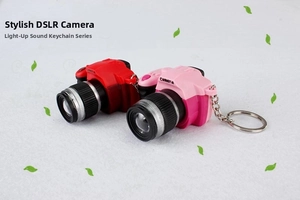 Close-up of red and pink mini SLR camera keychains with LED light and sound effects