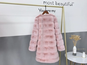 Detail of light pink faux fur coat showing horizontal panel stitching and soft plush texture