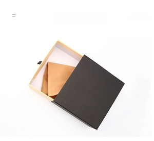 Detail of drawer-style black textured gift box with orange waffle fabric inside