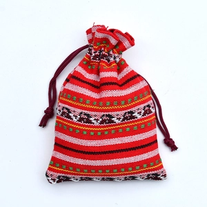 Detailed close-up of ethnic red drawstring pouch with colorful woven geometric patterns